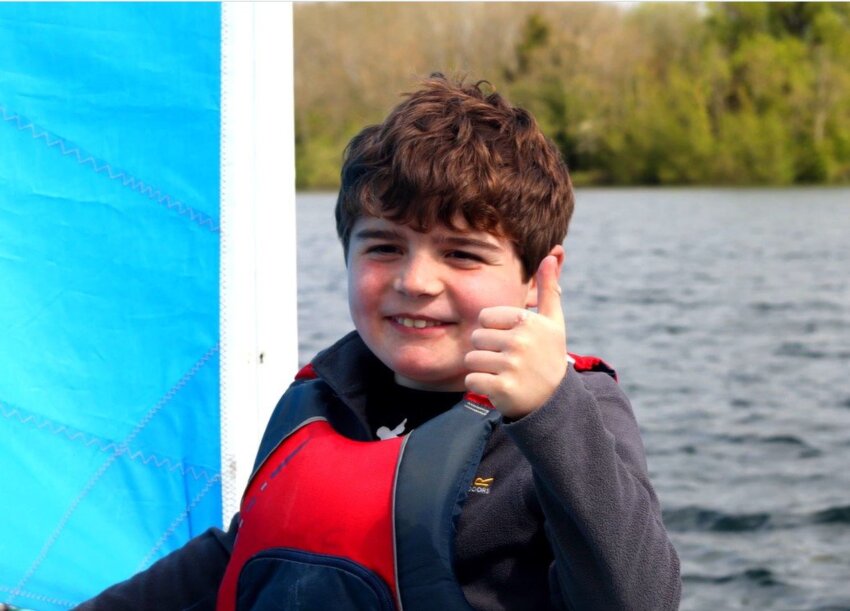 Felix giving a thumbs up at a lake