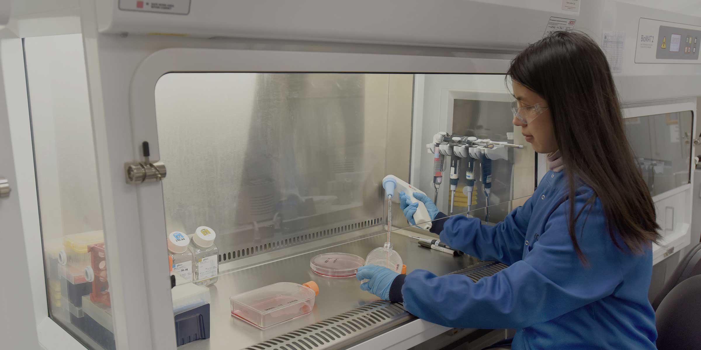 Scientist pipetting in a fume cupboard